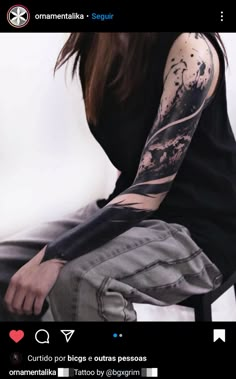 a woman with tattoos on her arm sitting down