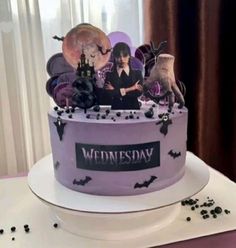 there is a cake that has decorations on the top and bottom of it, with an image of a woman surrounded by bats