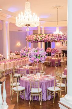 the tables are set with purple and pink flowers