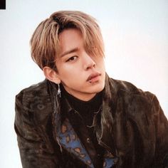 a young man in a leather jacket posing for a photo with his hand on his hip