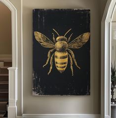 a painting of a bee on a black and gold background hangs in the entryway