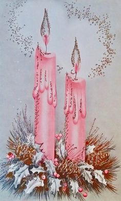 two pink candles sitting on top of a table next to pine cones and holly wreath