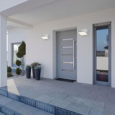 the entrance to a building with steps leading up to it and potted plants on either side