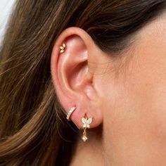 a close up of a person wearing some kind of earring with flowers on it