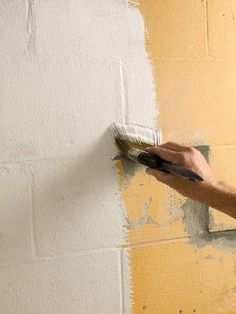 a man is painting the wall with a brush