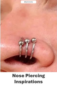 the nose piercing is being displayed with three balls attached to it