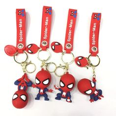 four spiderman keychains are shown with each other