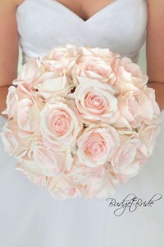 a bride holding a bouquet of pink roses