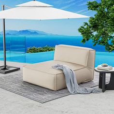 an outdoor area with a couch, table and umbrella on the ground next to a pool