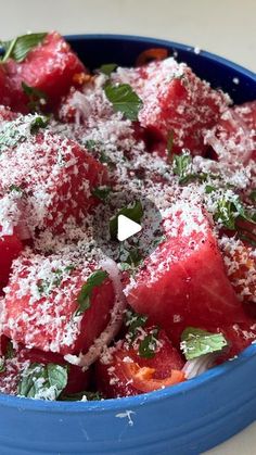 a blue bowl filled with watermelon and parmesan cheese