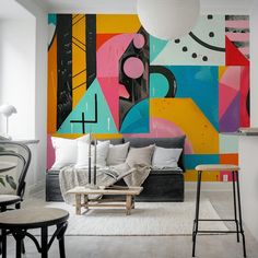 a living room filled with furniture next to a colorful wall