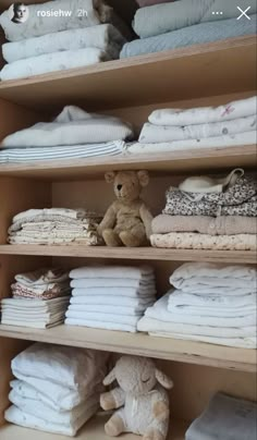 the shelves are full of folded clothes and stuffed animals, including a teddy bear on one end