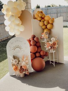 an outdoor display with balloons, flowers and other decorations on it's side table