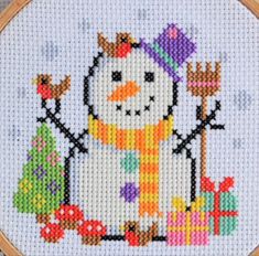 a cross stitch snowman with presents on it