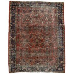 an antique rug with red, blue and black colors on the middle is shown in full view