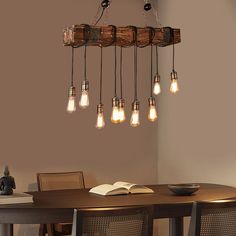 a wooden table topped with lots of light bulbs hanging from it's center beam