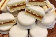 a pile of white and brown pastries sitting on top of a wooden table