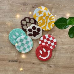 four handmade patches with dog paw prints on them sitting next to a green plant