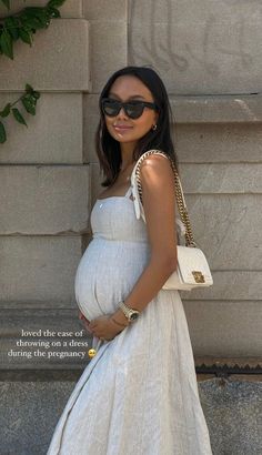 a pregnant woman in a white dress and sunglasses