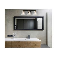 a bathroom vanity with two lights and a mirror on the wall above it is shown