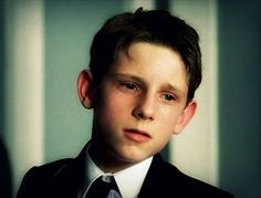 a young boy in a suit and tie looking at the camera with an intense look on his face