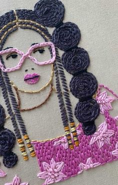 a woman's face with glasses and braids on a piece of fabric that has flowers in it