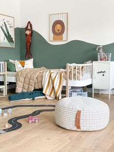 a child's bedroom with green walls and white furniture, including a toy train track