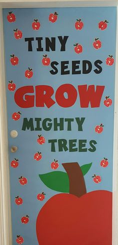 a door decorated with an apple and the words tiny seeds grow mighty trees