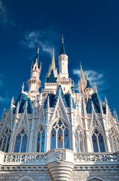 the castle is white and blue with many windows on it's sides, as well as two towers