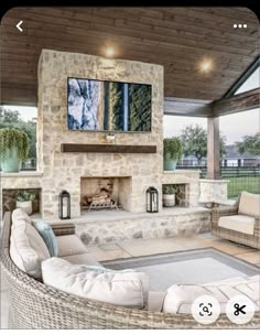 an outdoor living room with couches and fireplace