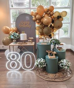 a table topped with cakes and balloons in front of a window