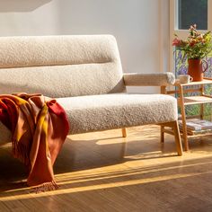 a white couch sitting on top of a hard wood floor