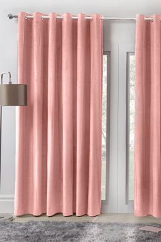 a pink curtain hanging in front of a window