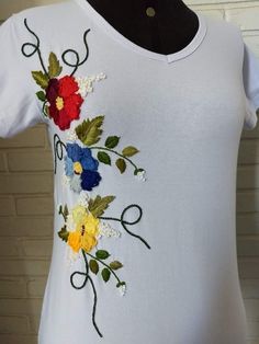 a white t - shirt with colorful flowers on the front and back, embroidered onto it