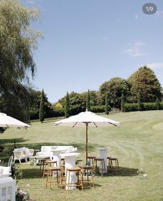 tables and chairs with umbrellas set up in the grass