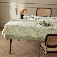 a dining room table with an empty plate on it and two chairs in front of the table