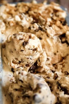 a scoop of ice cream sitting on top of a metal pan filled with chocolate chip cookies