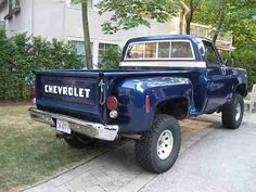 a blue pick up truck parked in front of a house