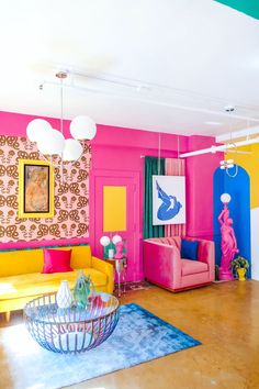 a brightly colored living room with pink, yellow and blue furniture in the center area