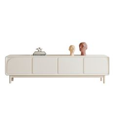 the sideboard is white and has three different shapes on it, including two heads