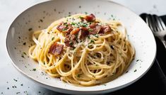 a white bowl filled with pasta and bacon