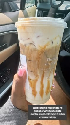 a woman holding up a cup with ice cream and caramel drizzle on it