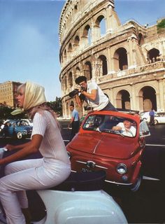 a woman riding on the back of a red scooter