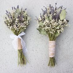 two bouquets of flowers tied together with twine and burlap, sitting next to each other