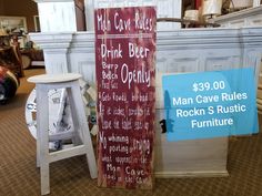 two wooden signs sitting on top of a carpeted floor next to white stools