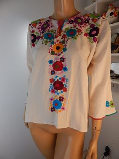 mexican blouse is totally handmade and in New condition.  This is a semi coarse heavy muslin that has traditionally been used for handmade mexican clothes.  It may shrink when washed.  Handwashing is recommended.  The embroidery is all done by hand.  bust 46 length 24 free shipping Multicolor Cotton Blouse With 3/4 Sleeves, Cotton Blouse With Floral Embroidery And 3/4 Sleeves, Bohemian Cotton Blouse With 3/4 Sleeves, White Cotton Hippie Blouse, Bohemian Embroidered Blouse With 3/4 Sleeves, Bohemian White Peasant Top With 3/4 Sleeves, Traditional Multicolor Cotton Peasant Top, Cinco De Mayo Cotton Blouse With Multicolor Embroidery, Embroidered Cotton Blouse For Cinco De Mayo