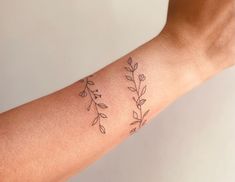 a woman's arm with two small flowers on the left side of her arm