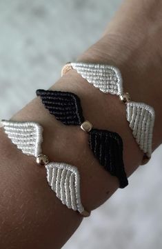 three white and black bracelets on someone's arm