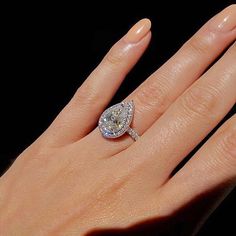 a woman's hand with a diamond ring on it