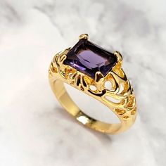 Simulated Gemstone Gold Plated Alloy Base Size 10 Filigree Style Gold Tone Ring With Faceted Rectangle Purple Amethyst Simulated Gemstone Elegant Amethyst Crystal Ring With Gemstone Accents, Elegant Purple Crystal Ring With Accent Stones, Elegant Lavender Crystal Ring, Purple Crystal Ring With Accent Stones For Formal Occasions, Formal Purple Crystal Ring With Accent Stones, Gold Amethyst Jewelry With Stone Setting, Elegant Purple Amethyst Ring With Stone Setting, Elegant Gold Amethyst Crystal Ring, Formal Gold Amethyst Crystal Ring